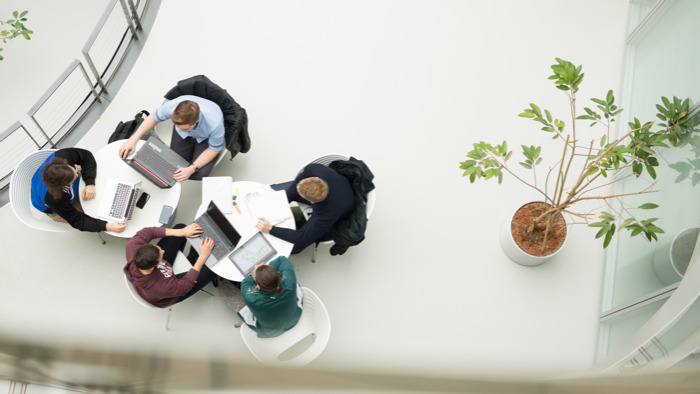 Vier Personen arbeiten gemeinsam an einem Projekt.