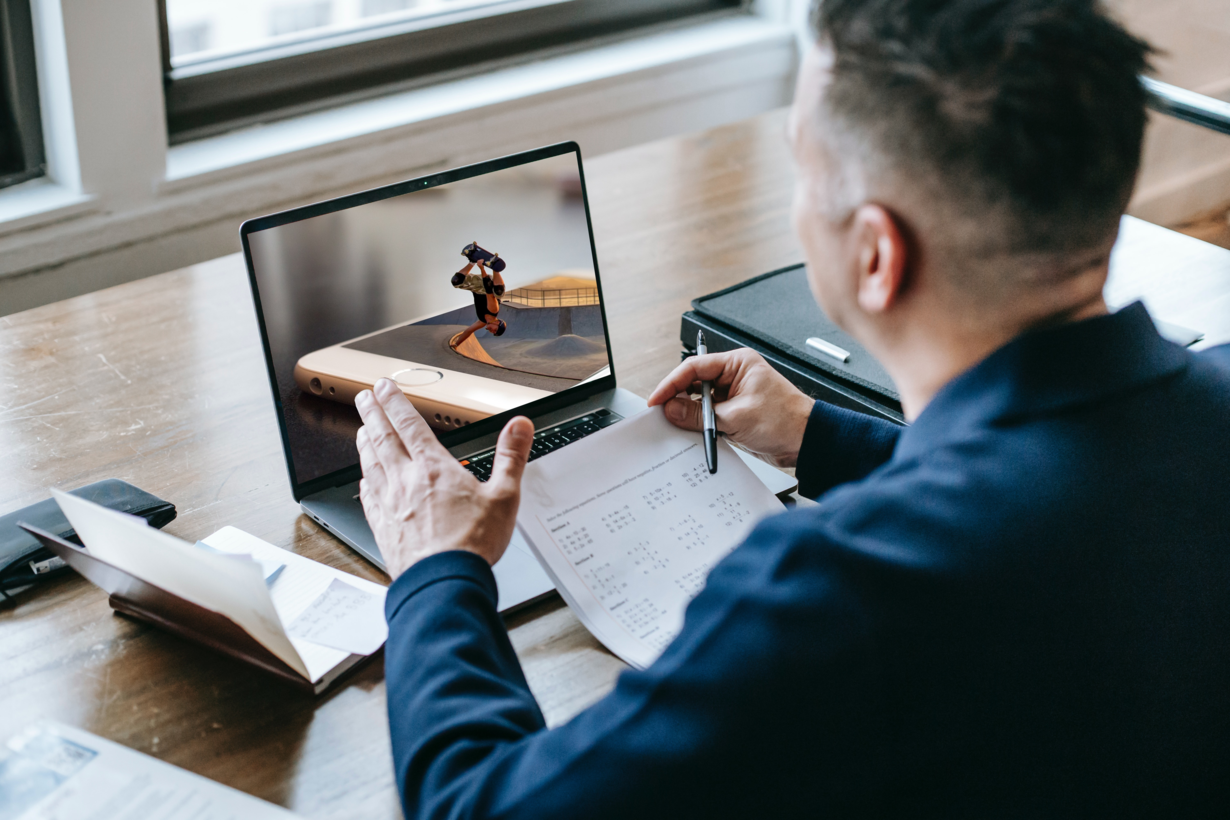 Ein Mann sitzt vor einem Laptop und gestikuliert